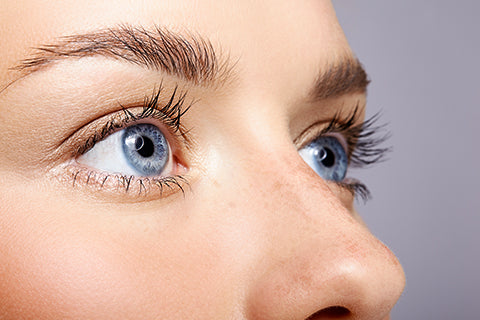 zoom yeux bleu femme avec fond gris