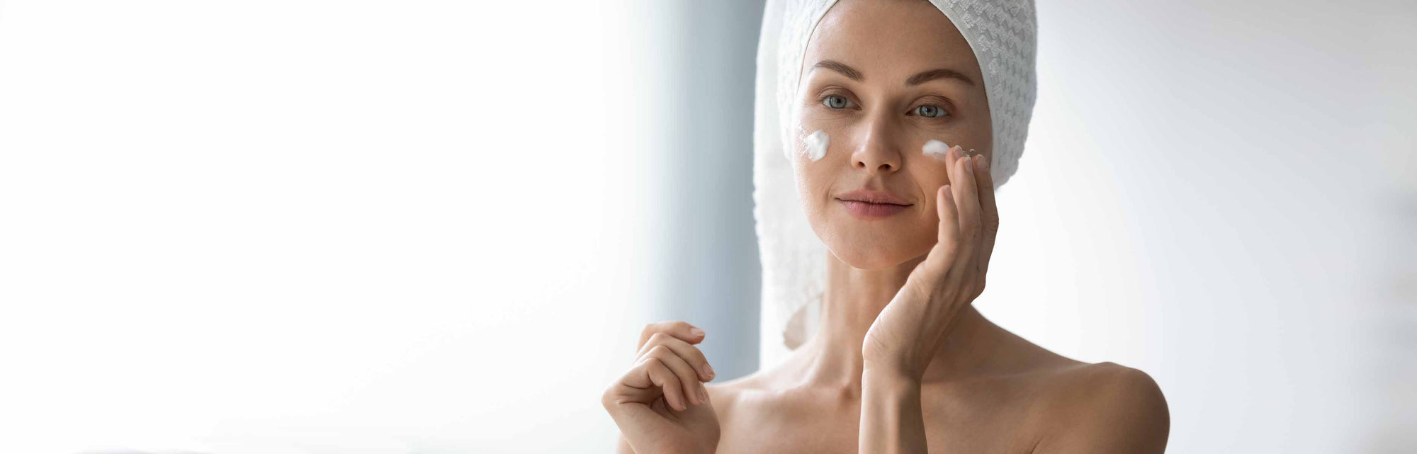 Femme appliquant une crème visage dans une routine de soins bio et vegan IUM Paris, illustrant l’efficacité et la douceur des formules naturelles pour tous les types de peau.