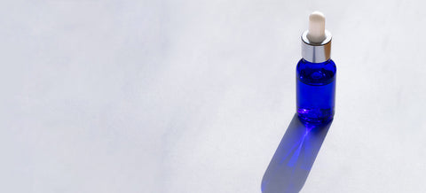 flacon ium bleu sur fond gris avec ombre