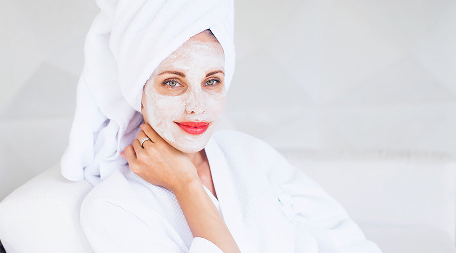 Belle femme avec masque IUM sur le visage de face avec une serviette blanche sur la tête