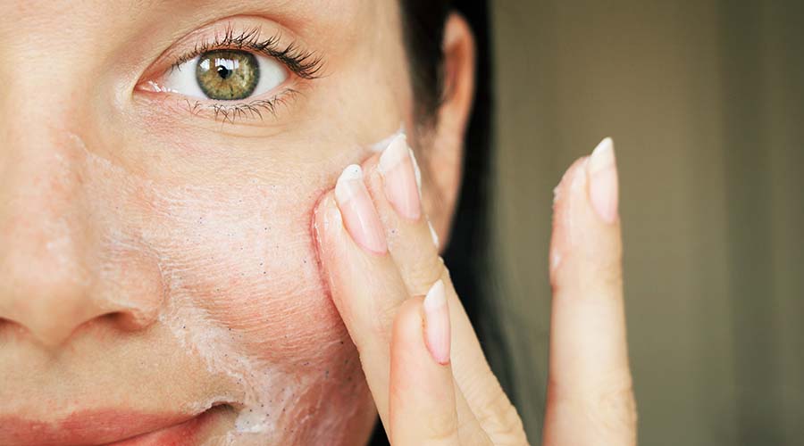 visage femme de face applique la gelée ium sur sa joue pour lutter contre l'acné