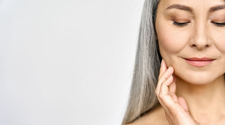 visage belle femme mature de face avec rides d'expression et cheveux gris sur fond blanc