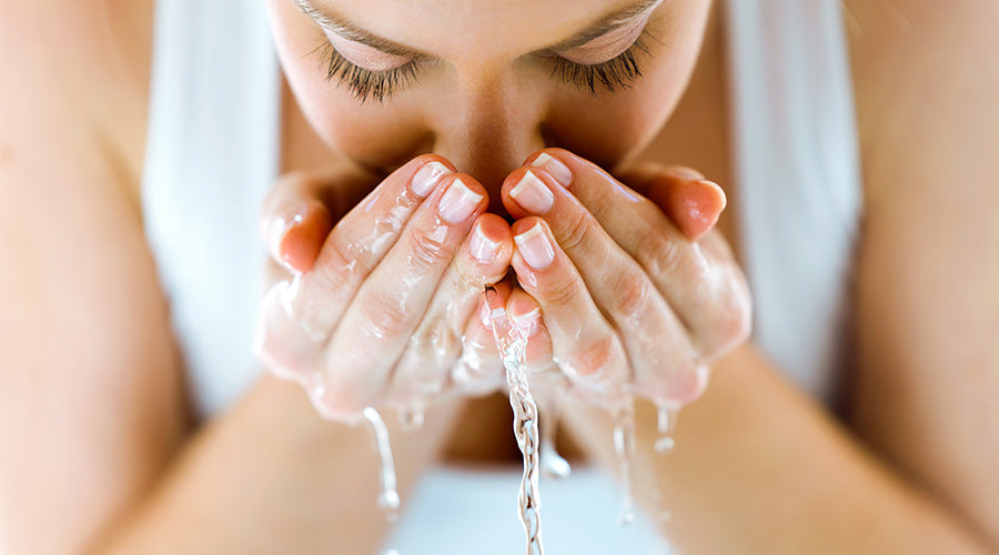 zoom sur une femme naturelle se rinçant le visage avec de l'eau